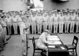 General Douglas MacArthur signs as Supreme Allied Commander during formal surrender ceremonies on the USS Missouri in Tokyo Bay. Behind General MacArthur are Lieutenant General Jonathan Wainwright and Lieutenant General A. E. Percival.<br/><br/>

On August 28, the occupation of Japan by the Supreme Commander of the Allied Powers began. The surrender ceremony was held on September 2 aboard the U.S. battleship Missouri, at which officials from the Japanese government signed the Japanese Instrument of Surrender, ending World War II.